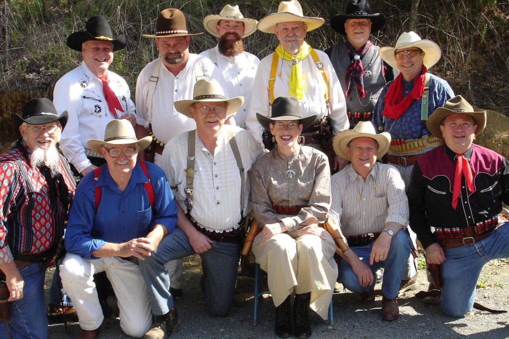 A Posse of Smiling Shooters And One Scowling at the Camera.